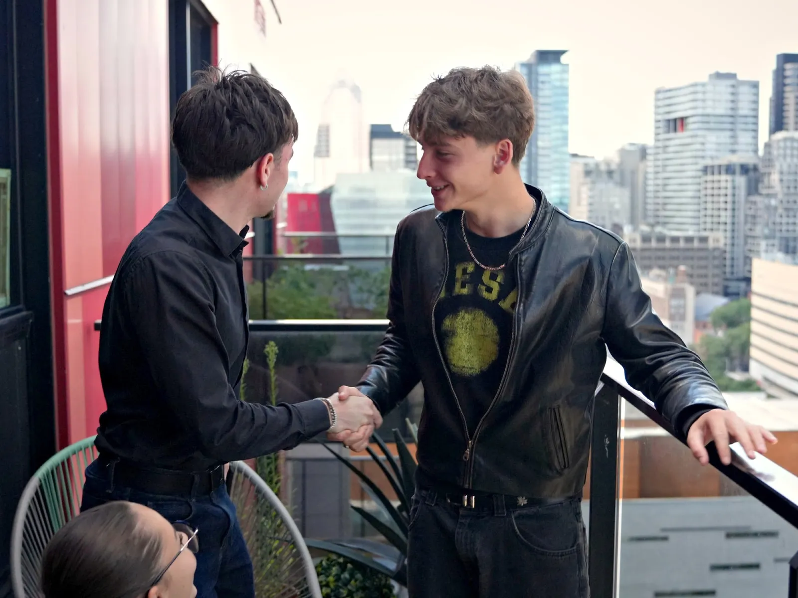 Poignée de main entre un fondateur de PULSE O et un client, sur la terrasse du bureau à Montréal.