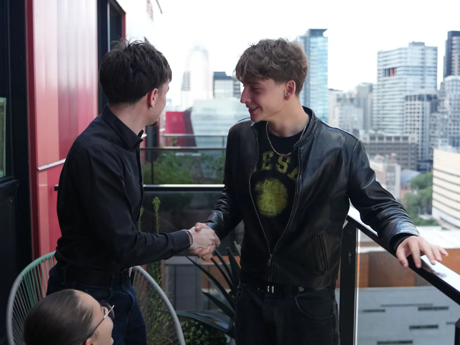 Poignée de main entre un fondateur de PULSE O et un client, sur la terrasse du bureau à Montréal.